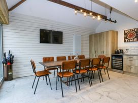 A dining room with a large table and chairs at Gowan Brae Criccieth
