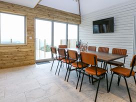 A dining room with a table and chairs at Gowan Brae in Criccieth