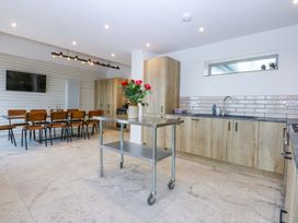 A kitchen with a dining table and chairs at Gowan Brae Criccieth