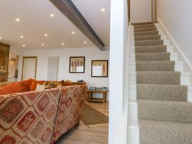 A living room with a sofa and stairs at Gowan Brae in Criccieth