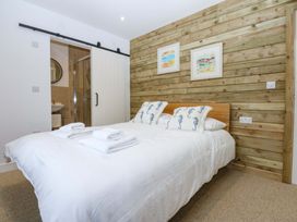 A bedroom with a bed and sliding door at Gowan Brae in Criccieth