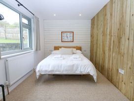 A bedroom with a bed and window at Gowan Brae in Criccieth