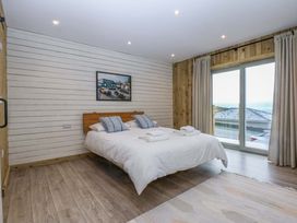 A bedroom with a bed and window at Gowan Brae in Criccieth
