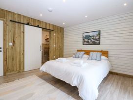 A bedroom with a double bed and a sliding door at Gowan Brae Criccieth