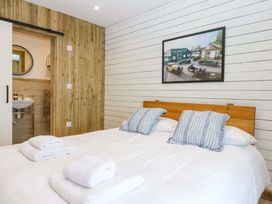 A bedroom with a bed and bathroom access at Gowan Brae in Criccieth