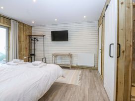 A bedroom with a bed and television at Gowan Brae in Criccieth