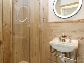 A bathroom with a shower and sink at Gowan Brae in Criccieth