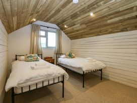 A bedroom with two beds and a window at Gowan Brae in Criccieth