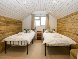 A bedroom with two single beds and a window at Gowan Brae in Criccieth