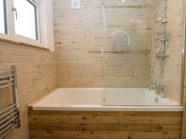 A bathroom with a bathtub and shower at Gowan Brae in Criccieth