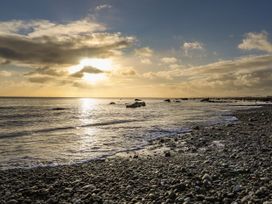 A beach scene with pebbles and water at Gowan Brae in Criccieth