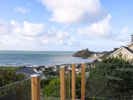 A view of the ocean with houses and hills at Gowan Brae in Criccieth