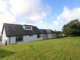 A house with a lawn and trees at Gowan Brae in Criccieth