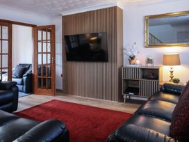 A living room with a television and a sofa at Penrhos Walks Holyhead