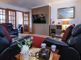 A living room with sofas, coffee table and television at Penrhos Walks in Holyhead