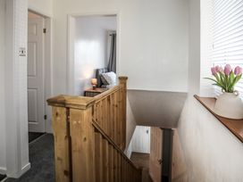 A hallway with a staircase and a plant at Penrhos Walks in Holyhead