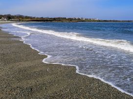 A beach with pebbles and waves at Penrhos Walks in Holyhead
