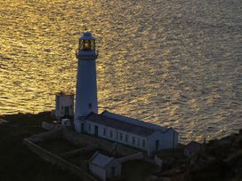 A lighthouse beside water at Penrhos Walks in Holyhead