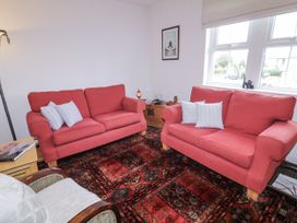 A living room with two red sofas and a wooden table at Burna in Letterkenny