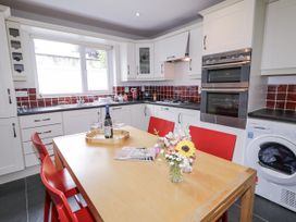 A kitchen with a dining table and red chairs at Burna in Letterkenny