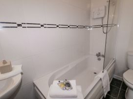 A bathroom with a bathtub, toilet, sink, and bath products at Burna in Letterkenny