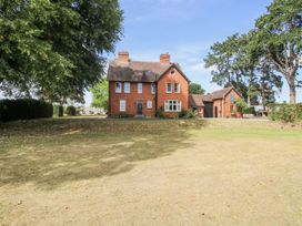 A house with trees and a lawn at The Old Vicarage in Kimbolton near Leominster