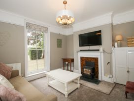 A living room with a television and fireplace at The Old Vicarage in Kimbolton near Leominster