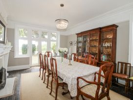A dining room with a long table and chairs at The Old Vicarage in Kimbolton near Leominster