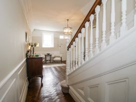 A hallway with stairs and a table at The Old Vicarage Kimbolton near Leominster