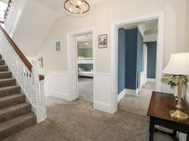 A hallway with a staircase and doorways at The Old Vicarage in Kimbolton near Leominster