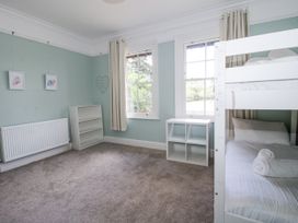 A bedroom with a bunk bed and bookshelf at The Old Vicarage Kimbolton near Leominster