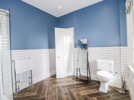 A bathroom featuring a toilet, mirror, and towel rail at The Old Vicarage in Kimbolton near Leominster