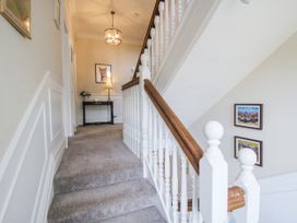 A staircase with handrail and console table in the hallway at The Old Vicarage in Kimbolton near Leominster