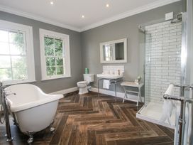 A bathroom with a bathtub, sink, toilet and shower at The Old Vicarage in Kimbolton near Leominster