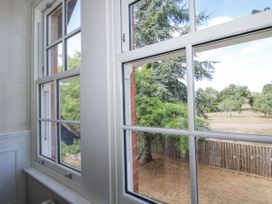 A view from a window showing trees and a fence at The Old Vicarage Kimbolton near Leominster