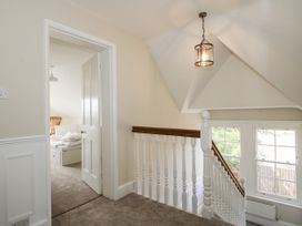 A hallway with a staircase and a door leading to a bedroom at The Old Vicarage Kimbolton near Leominster