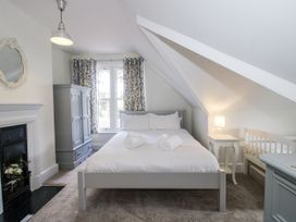 A bedroom with a bed and crib at The Old Vicarage Kimbolton near Leominster