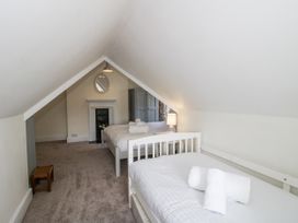 A bedroom with two beds and a mirror at The Old Vicarage Kimbolton near Leominster