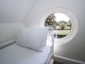 A bedroom with a bed and a round window at The Old Vicarage in Kimbolton near Leominster