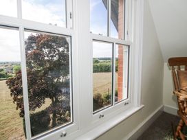 A room with a window showing a tree and a field at The Old Vicarage in Kimbolton near Leominster