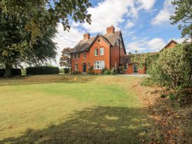 A house with a lawn and trees at The Old Vicarage Kimbolton near Leominster