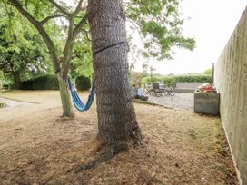 A garden with a hammock and patio seating area at The Old Vicarage Kimbolton near Leominster