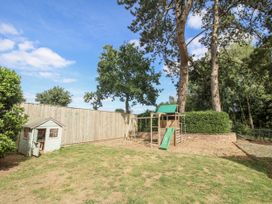 A garden with play equipment and trees at The Old Vicarage in Kimbolton near Leominster