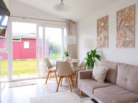 A living room with a sofa and dining area at Cozy Retreat in Tregolds