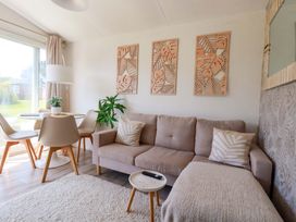 A living room with a sofa and dining table at Cozy Retreat in Tregolds