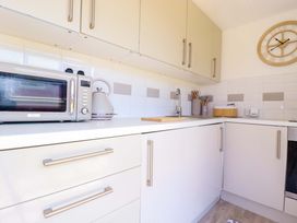 A kitchen with a microwave, kettle, and sink at Cozy Retreat in Tregolds
