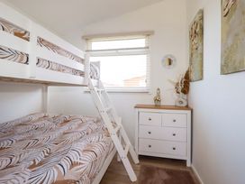 A bedroom with a bunk bed and dresser at Cozy Retreat in Tregolds