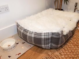 A dog bed and bowl in a living room at Ocean Edge Sennen Cove