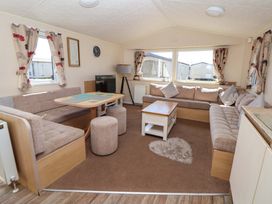 A living room with a sofa and table at Willerby Aurora B14 Towyn