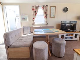 A dining area with a table and upholstered seating at Willerby Aurora B14 Towyn